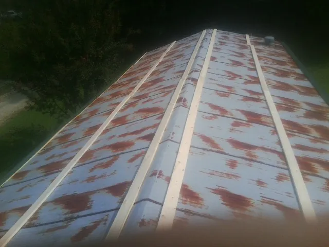 Rusted metal roof panels with new wood purlins before replacement — Storm Damage Roof Repair in Clyo by Roofing Brothers
