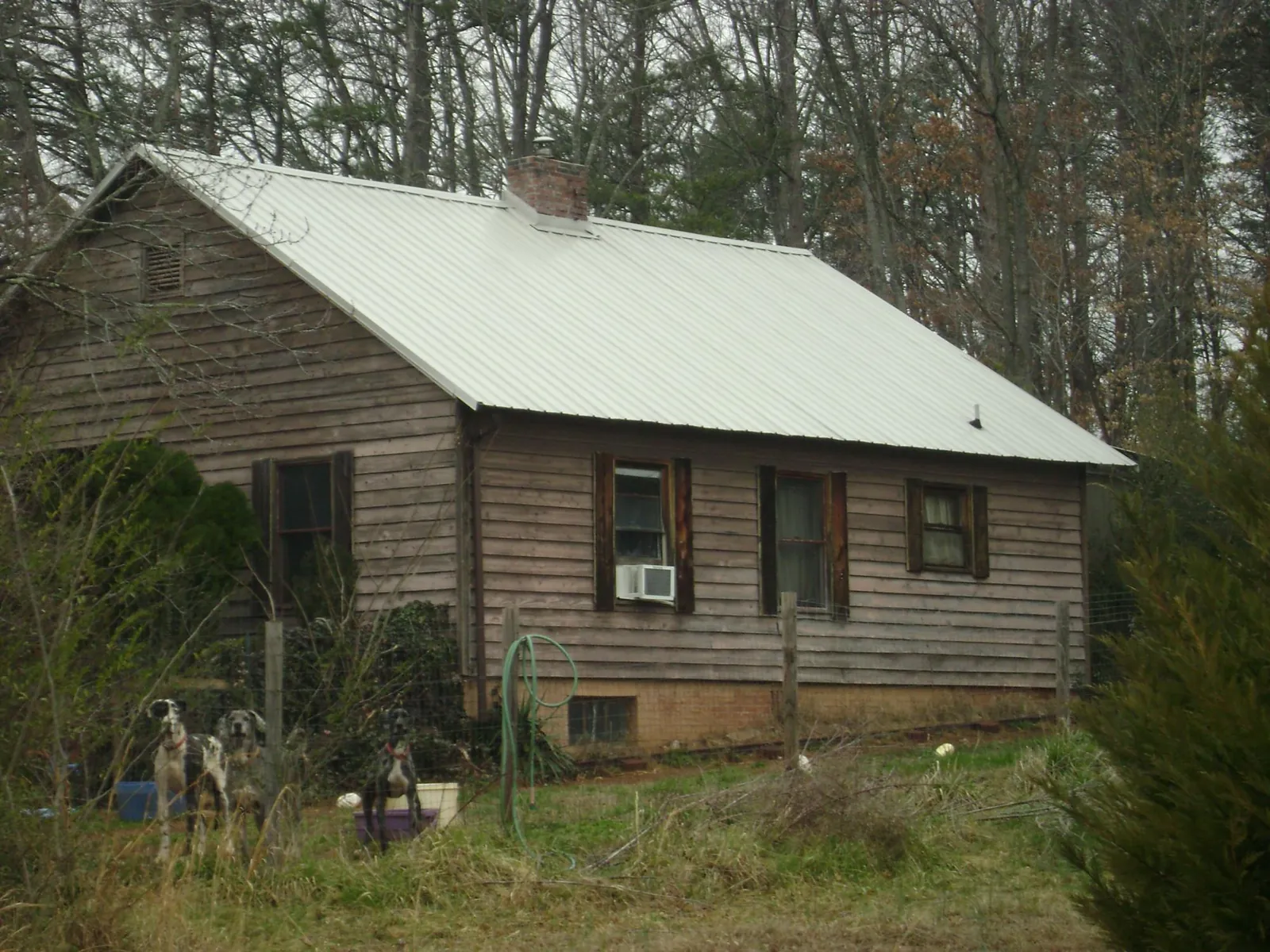 White metal roof on an old wood sided farmhouse, from a Metal Roof Installation job in Clyo